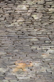 Stone wall made of gray textured stones 