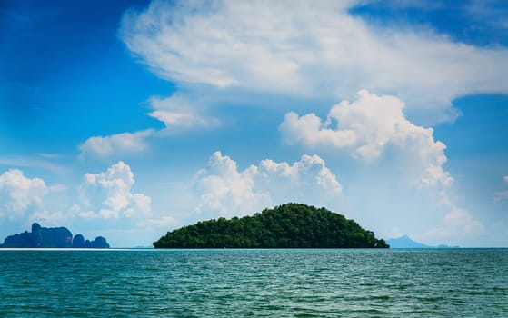 Desert island in the ocean and colorful cloudy sky