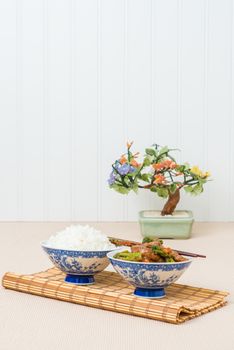 Bowl of stir fried beef and broccoli served with white rice.