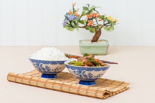 Bowl of stir fried broccoli and beef with steamed white rice.