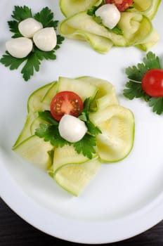 Snack in the form of roses from zucchini , mozzarella and cherry tomatoes