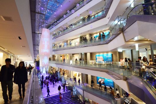 Tokyo, Japan - November 24, 2013: People shopping in Omotesando Hills on november 2013. 24,  Omotesando Hills consists of six floors (three are underground) of about 100 upmarket shops, cafes, restaurants and beauty salons.
