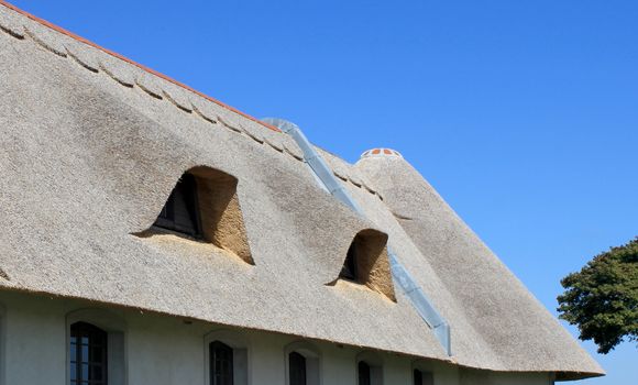 Cover thatch roof of a cottage on a blue sky background