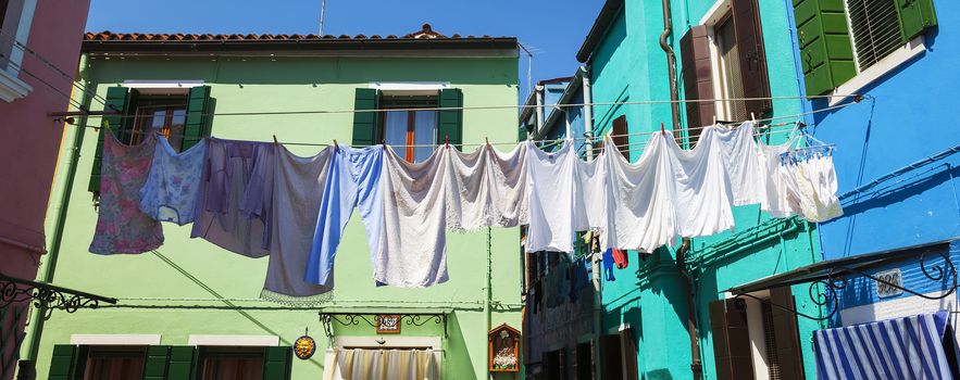 Washing lines with clothes drying in back yard in Burano.