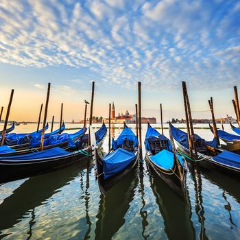 Gondolas in lagoon of Venice on sunrise, Italy
