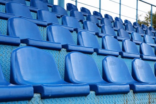 Empty plastic seats at stadium, open door sports arena.