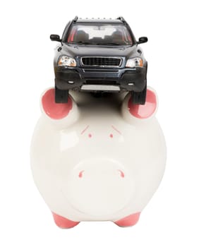 Car on piggy bank isolated on white background