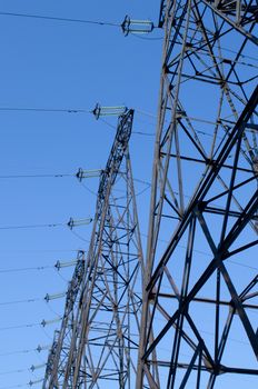 supports of high-voltage power lines against the blue sky