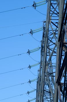 supports of high-voltage power lines against the blue sky