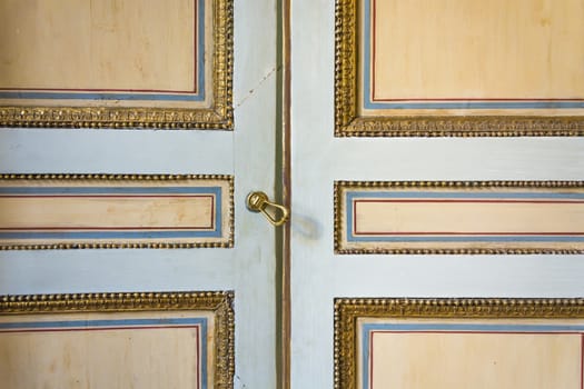 an old painted door decorated with gold, blue and red lines