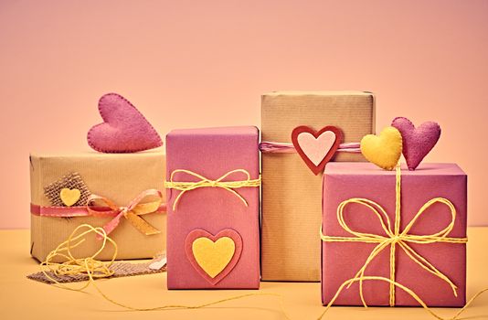 Love hearts, Valentines Day. Handcraft gift boxes, presents stack. Couple of hearts. Retro romantic styled. Vintage retro concept, unusual greeting card. Kraft paper, multicolored felt, copyspase