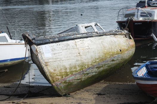 Wreck.

Old and decrepit boat pulled onto land. You would not want to sail in this one.