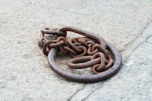 Old and rusted.

Iron ring and chain in the port of Looe, Cornwall, used to tying up of boats to harbour.