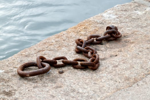 Old and rusted.

Iron ring and chain in the port of Looe, Cornwall, used to tying up of boats to harbour.