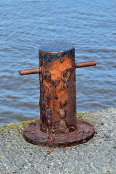 Old and rusted.

Bollard at a boat yard in Cornwall, used to tying up of boats to harbour.