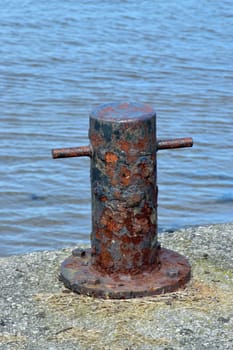 Old and rusted.

Bollard in old boat yard in Cornwall, used for tying up of boats to harbour.