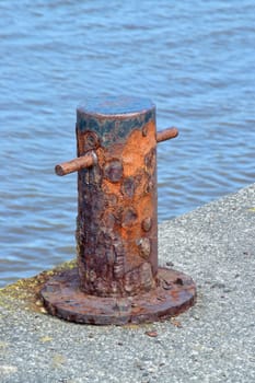 Old and rusted.

Bollard in old boat yard in Cornwall, used for tying up of boats to harbour.