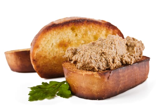 Fried bread with liver pate and parsley leaves on a white background