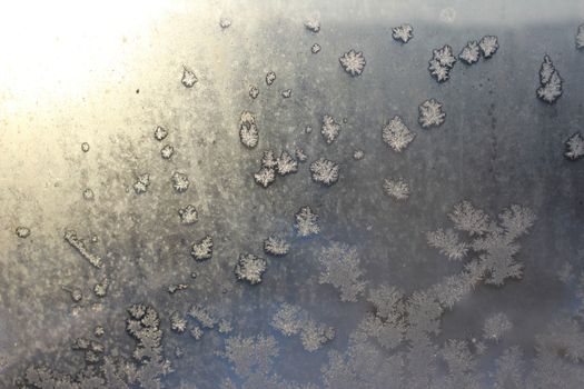 Frozen white window covered with frost in winter patterned.