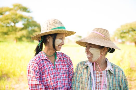 Portrait of a Myanmar female farmer with thanaka powdered face at farmland.
