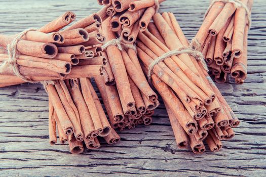 Tied Cinnamon stick with selective focus on old wooden background .