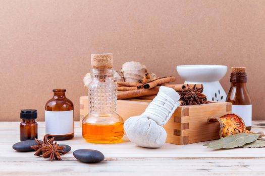 Bottle of essential oil with cinnamon stick ,star anise ,bay leaves with selective focus on old wooden background .