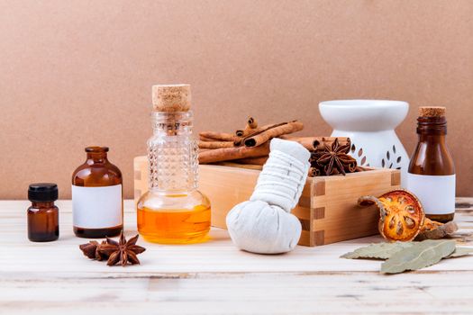 Bottle of essential oil with cinnamon stick ,star anise ,bay leaves with selective focus on old wooden background .