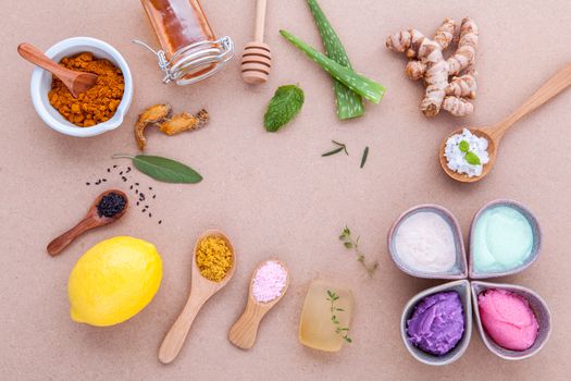 Alternative skin care and homemade scrubs with natural ingredients sage ,turmeric ,sea salt ,honey, aloe vera,lemon ,rosemary,mint and sesame set up on brown table.