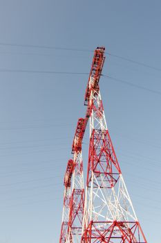 supports of high-voltage power lines against the blue sky