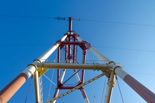 supports of high-voltage power lines against the blue sky