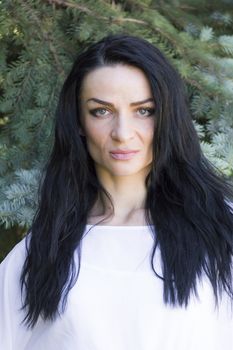European woman with black hair on green background