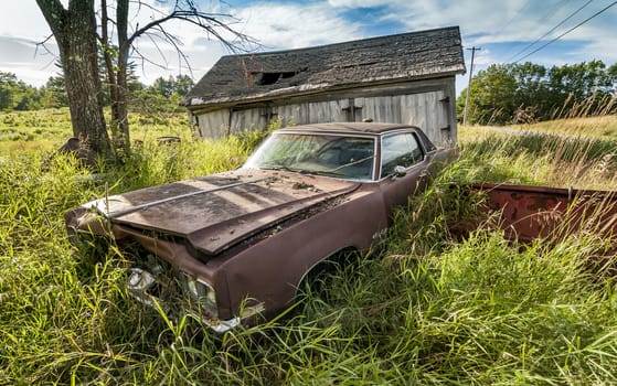old wrecking car in countryside in Maine, Usa