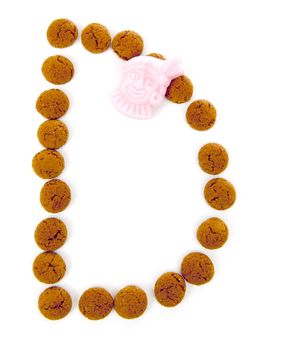 Ginger nuts, pepernoten, in the shape of letter D isolated on white background. Typical Dutch candy for Sinterklaas event in december