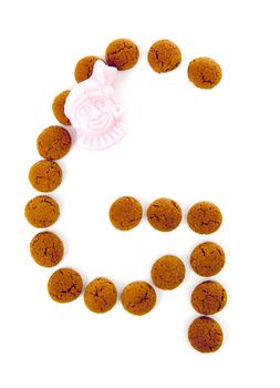 Ginger nuts, pepernoten, in the shape of letter G isolated on white background. Typical Dutch candy for Sinterklaas event in december