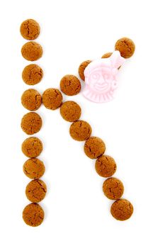 Ginger nuts, pepernoten, in the shape of letter K isolated on white background. Typical Dutch candy for Sinterklaas event in december