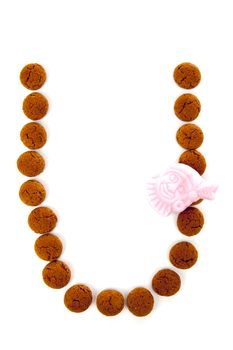 Ginger nuts, pepernoten, in the shape of letter U isolated on white background. Typical Dutch candy for Sinterklaas event in december