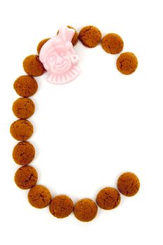 Ginger nuts, pepernoten, in the shape of letter C isolated on white background. Typical Dutch candy for Sinterklaas event in december