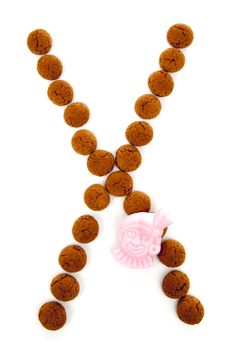 Ginger nuts, pepernoten, in the shape of letter X isolated on white background. Typical Dutch candy for Sinterklaas event in december