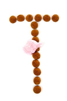 Ginger nuts, pepernoten, in the shape of letter T isolated on white background. Typical Dutch candy for Sinterklaas event in december