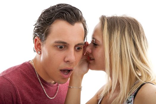 girl is whispering in ear of boyfriend isolated on white background nad he is startled