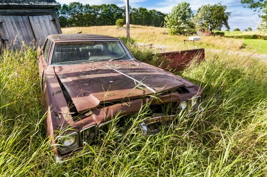 old wrecking car in countryside in Maine, Usa