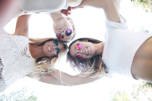 Underneath view of female friends with smiling faces outdoors