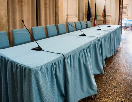 Conference table and chairs covered with blue cloth.