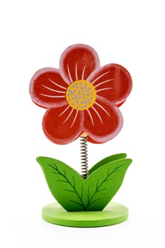 Red wooden flower with stem formed by a spring on white background.