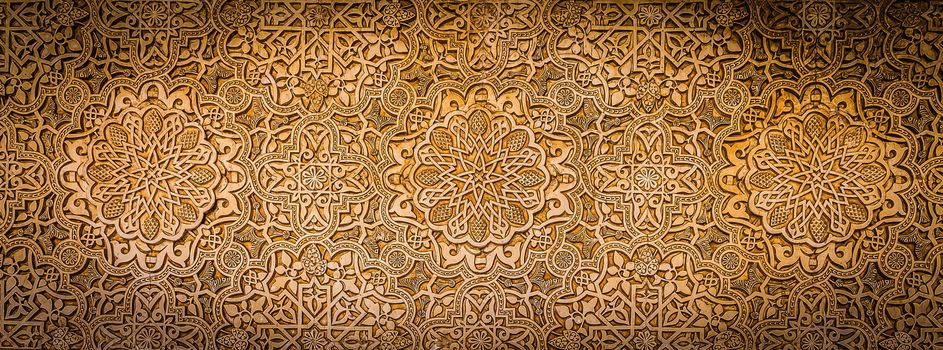 Wall detail of Alhambra UNESCO site in Granada - South of Spain. 600 years old arabic characters.