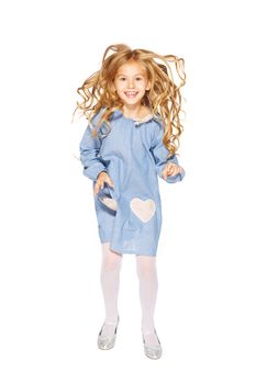 Jumping little girl in a blue dress with flying curls