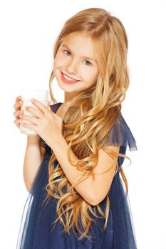 Cute little girl with blond hair in a blue dress holding a glass of milk