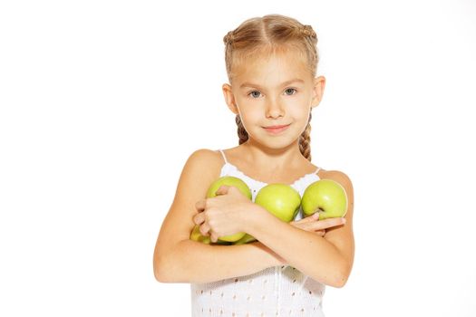 Cute little girl in a white dress bites red fresh apple