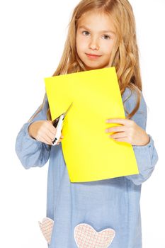 Little cute girl making handmade yellow hearts