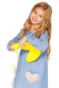 Little cute girl making handmade yellow hearts